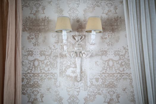 vintage lamp on the wall with Wallpaper with a floral pattern on edges of curtains