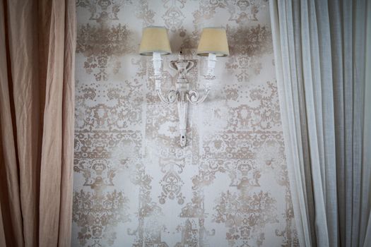 vintage lamp on the wall with Wallpaper with a floral pattern on edges of curtains