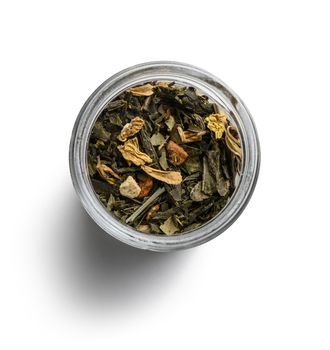 Green tea with aromatic additives. Top view on white background.