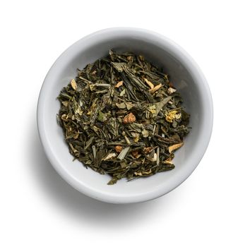Green tea with aromatic additives. Top view on white background.