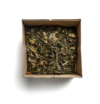 Green tea with aromatic additives. Top view on white background.