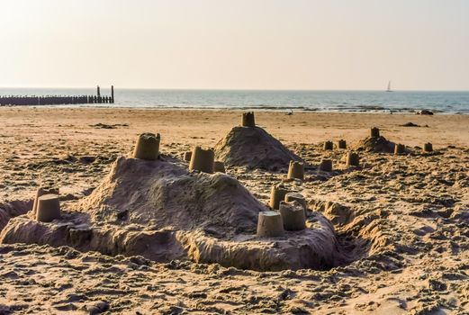 sand castle buildings on the beach with the ocean in the background, summer season and holidays