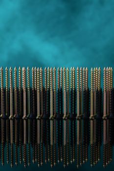 Screws and dowels on glass on turquoise background. Symbol of team work, invincibility and power of team army. Creative photo of screws and dowels.