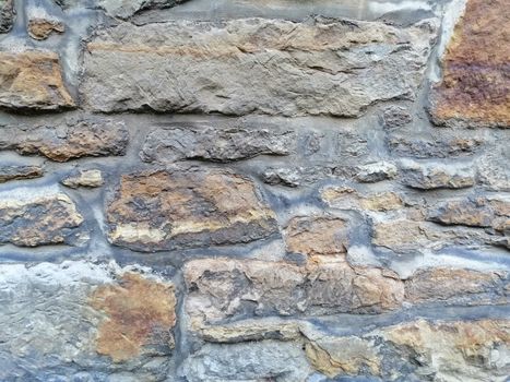 Old stone wall with moss and holes texture background.