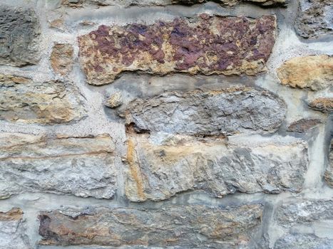 Old stone wall with moss and holes texture background.