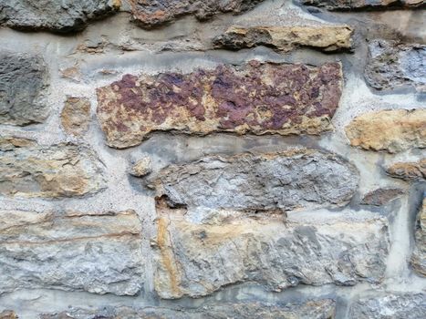 Old stone wall with moss and holes texture background.