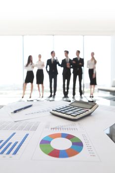 Close up view of printed graphs and business people discussing financial data