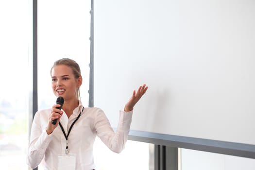 Business woman giving a presentation on blank white board with copy space