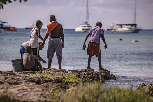 BAYAHIBE, DOMINICAN REPUBLIC 23 DECEMBER 2019: Poor Dominican children play in Bayahibe beach in total happiness and joy