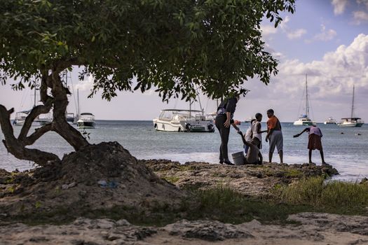 BAYAHIBE, DOMINICAN REPUBLIC 23 DECEMBER 2019: Poor Dominican children play in Bayahibe beach in total happiness and joy