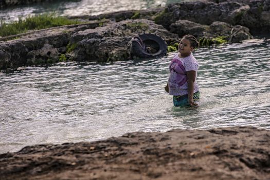 BAYAHIBE, DOMINICAN REPUBLIC 23 DECEMBER 2019: Poor Dominican children play in Bayahibe beach in total happiness and joy