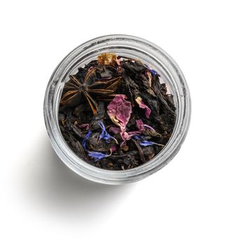 Black tea with natural aromatic additives. Top view on white background.