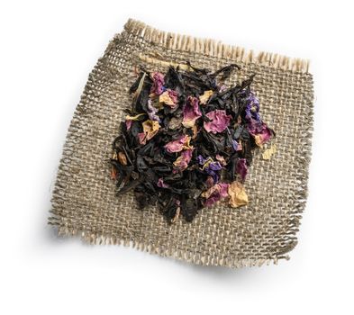 Black tea with natural aromatic additives. Top view on white background.