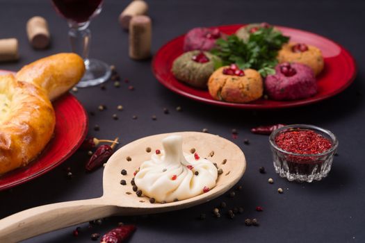 Georgian food on black table. khinkali, phali,  khachapuri with tomatos, adjika and a glass of wine.