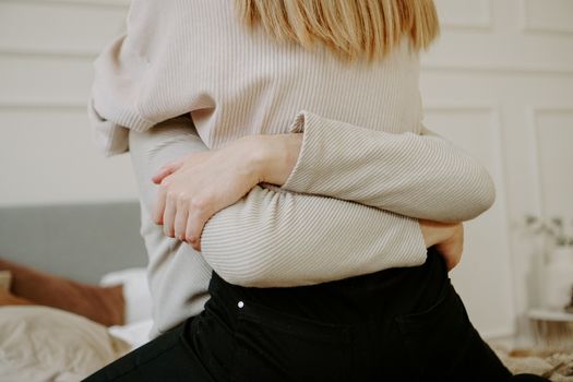 Close-up portrait of a beautiful young couple hugs in bed at home. Soft colors