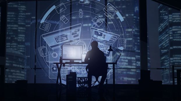 Silhouette of a web programmer sitting in a dark office with windows on a business center and infographics in front of him.