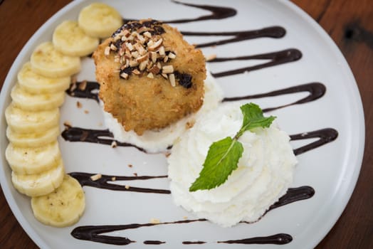 Fried ice cream served on wooden table background