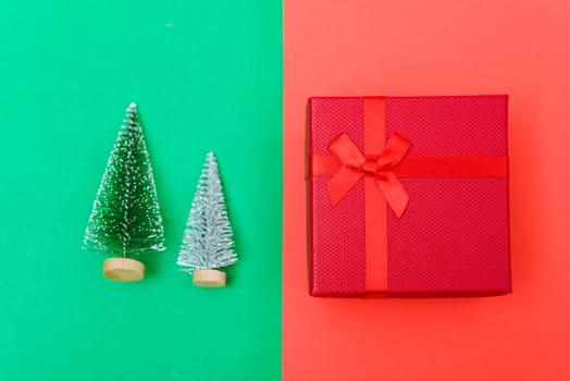 New Year, Christmas Xmas holiday composition, Top view green fir tree branch and red gift box on red and green background with copy space