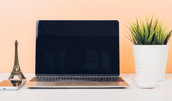 Mock up laptop notebook computer on desk table office soft yellow wall and blank screen