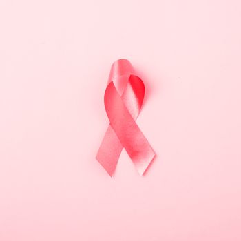 Breast Cancer Awareness Month concept, top view flat lay pink ribbon on pink background with copy space for your text
