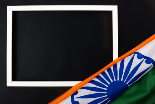 Indian republic day, flat lay top view, Indian flag and photo frame on black background with copy space for your text