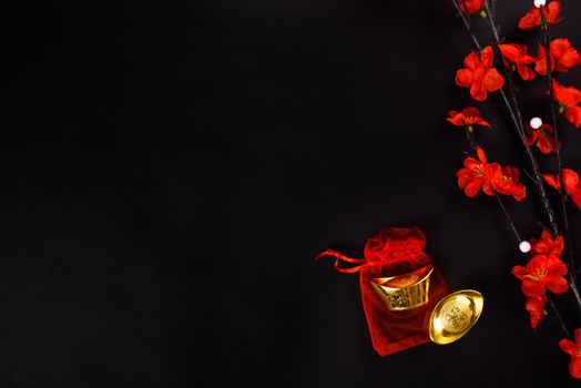 Chinese New Year, flat lay top view, gold bar and Chinese Flower on black background with copy space for your text