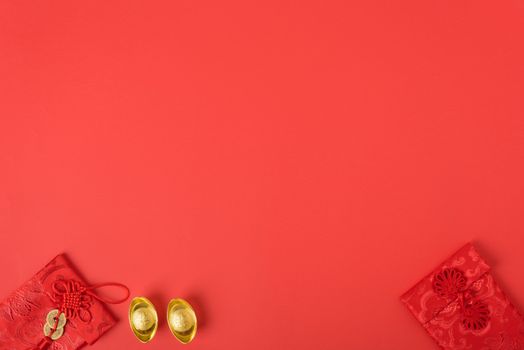 Chinese new year concept, flat lay top view, Happy Chinese new year with Red envelope and gold ingot (Character "FU" means fortune, blessing, wealth) on red background with copy space for your text