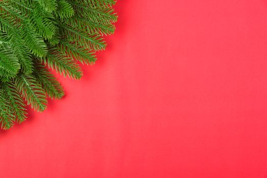 Happy new year or christmas day top view flat lay fir tree branches on red background with copy space for your text