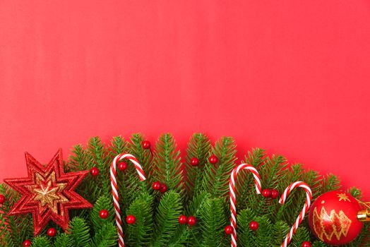 Happy new year or christmas day top view flat lay fir tree branches and ornaments decoration on red background with copy space for your text