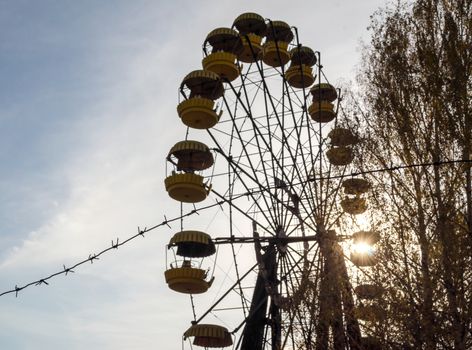 barbed wire and cabins old carousel wheel in an abandoned amusement park in Chernobyl Ukraine in autumn