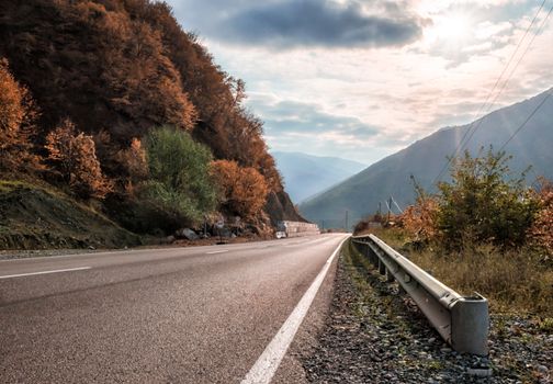 landscape mountain road and sky with sunbeams and clouds in Georgia in autumn