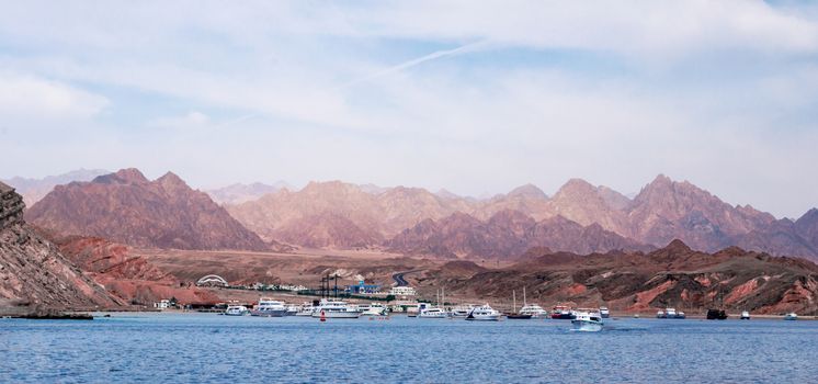 cruise boats near the rocky shore in Sharm El Sheikh Egypt