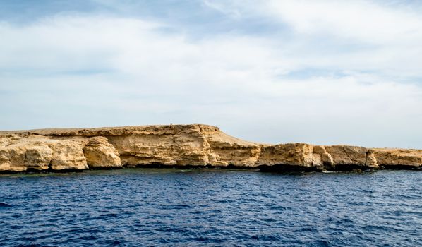 landscape rocky coast of the Red Sea and
blue sky with clouds in Sharm El Sheikh Egypt