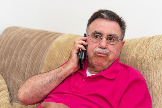 Portrait of a senior man serious expression talking on the phone