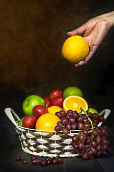 fresh vegetables and fruits in wicker basket over wooden background