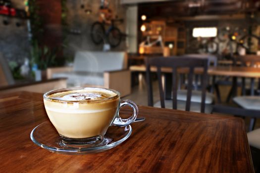 Cup of hot coffee latte on wood table in restaurant