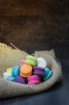 colorful of macarons on a sack over wooden table