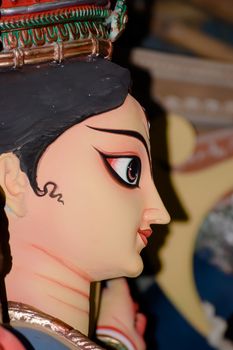 A side view close up portrait face of Goddess Durga idol, symbol of strength and slayer of evil and spirituality as per Hinduism. Kumartuli potter studio, Kolkata West Bengal India Asia October 2019