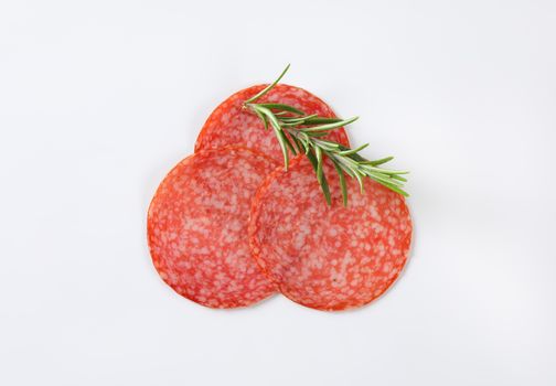 Thin slices of Hungarian salami and fresh rosemary