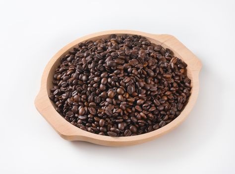 Roasted coffee beans on wooden tray
