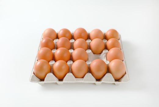 Carton of fresh brown eggs, one egg missing