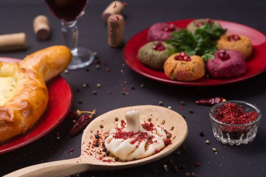 Georgian food on black table. khinkali, phali,  khachapuri with tomatos, adjika and a glass of wine.