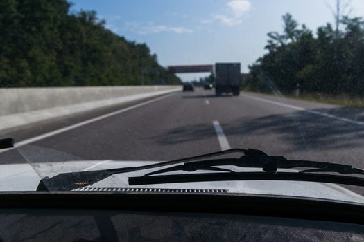 View of a passenger from the passenger compartment on the highway. A fine sunny day and almost free road. 