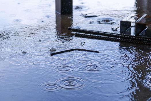 Rain drops and water on concrete with sky reflection in water