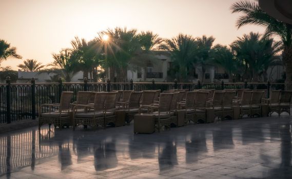 chairs on a terrace without people in a hotel at dawn with elephant rays in Sharm El Sheikh Egypt