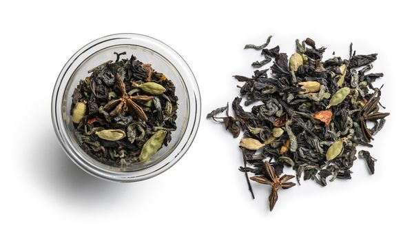 Green tea with aromatic additives. Top view on white background.