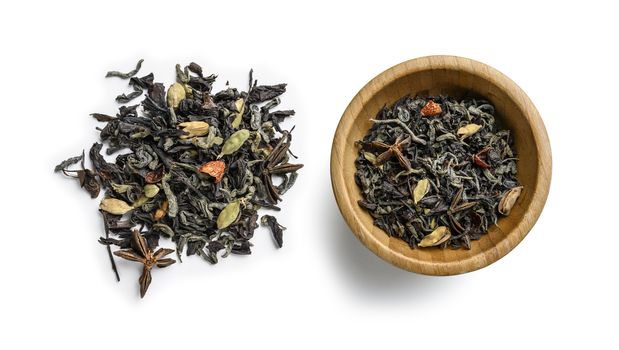 Green tea with aromatic additives. Top view on white background.