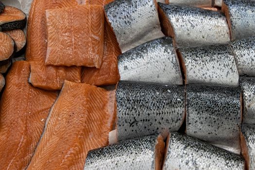 Different types of fresh fish on ice in supermarket, top view. Close up fresh fish on ice bucket or frozen fish in grocery store use for raw food background