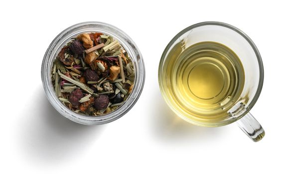 Green tea with natural aromatic additives and a Cup of tea. Top view on white background.