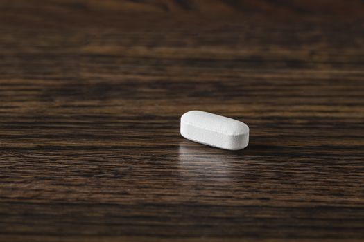 close-up of a white tablet against a dark wood background